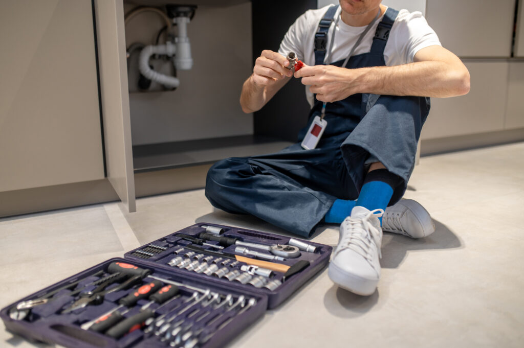 Métiers • man sitting on floor with plumbing detail in hands 2024 10 18 07 41 45 utc Métiers • man sitting on floor with plumbing detail in hands 2024 10 18 07 41 45 utc